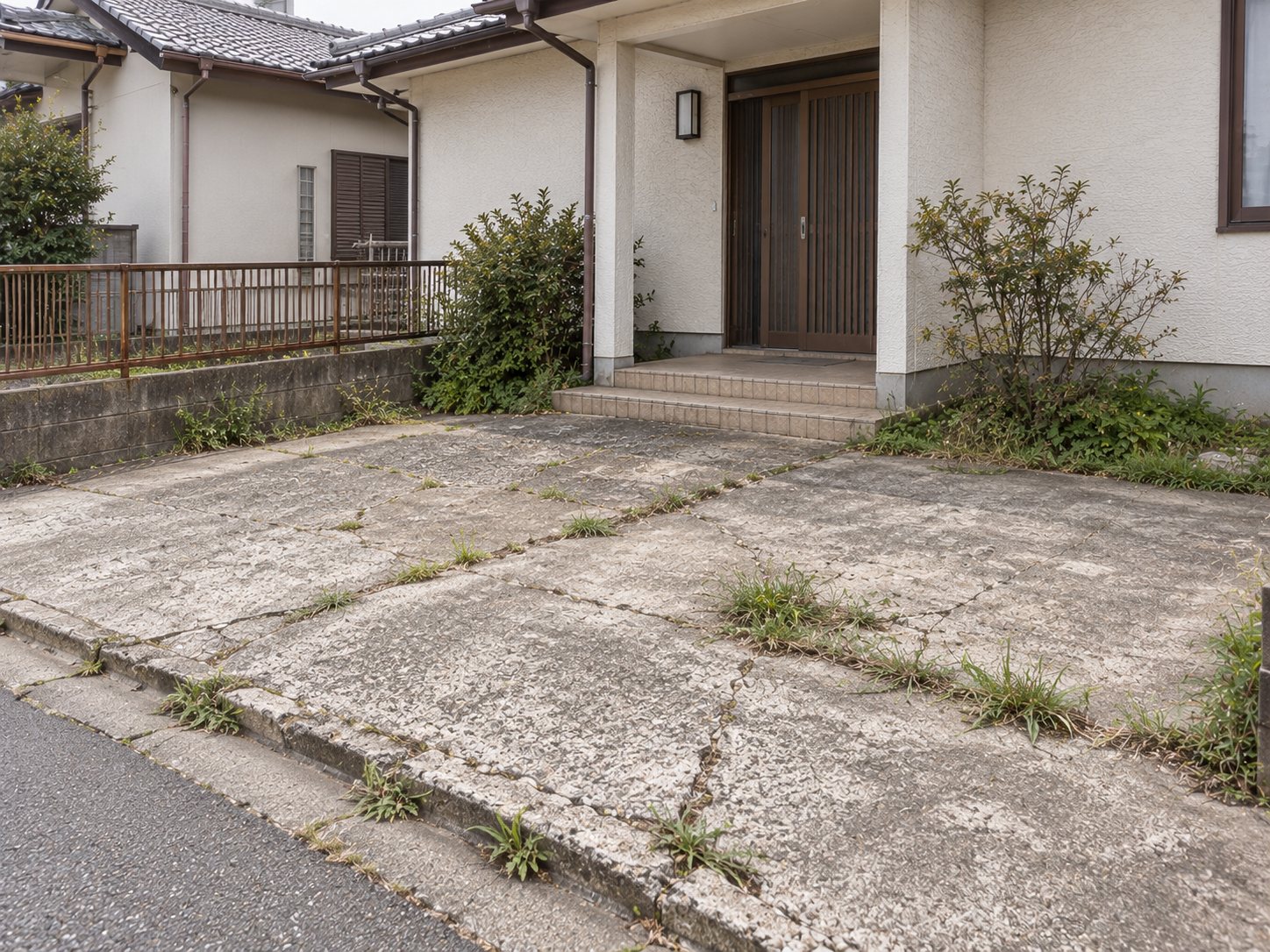 施工前。ひび割れた土間コンクリートと、錆の浮いた低いフェンス